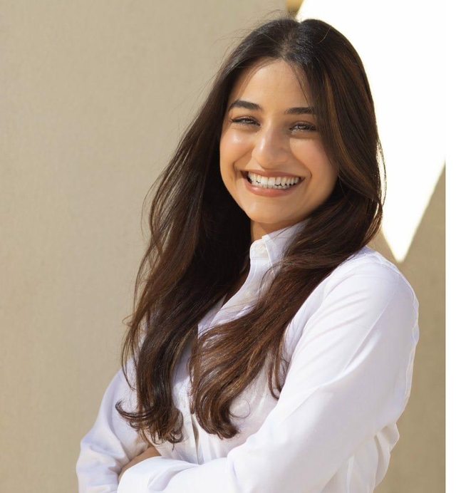Dr. Tojjar smiling in white blouse with arms crossed
